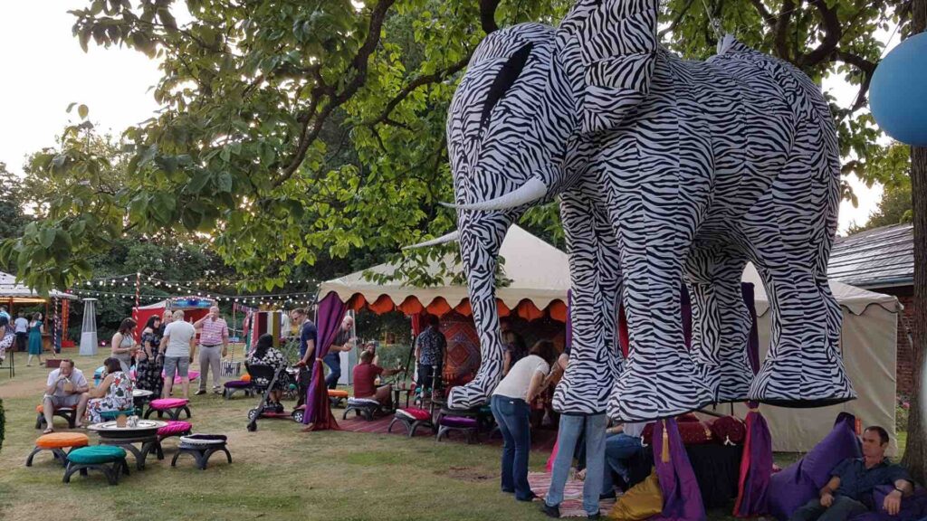 Elephant decor at a corporate fun day event overlooking festival themed space.