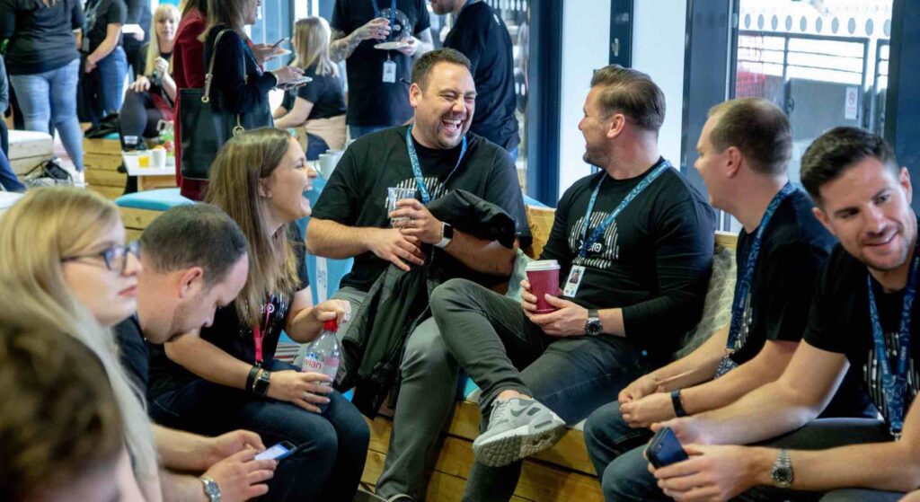 Delegates laughing and joking at a conference break out space produced by conference event planners.
