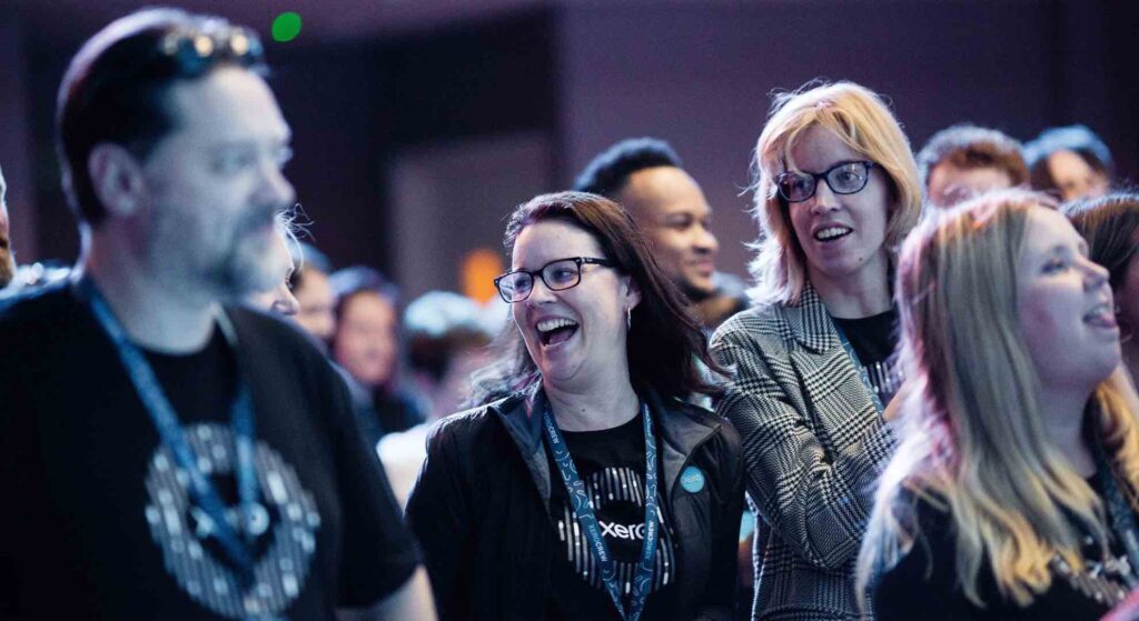 Employees laughing and enjoying themselves at XERO conference organised by professional event planners.