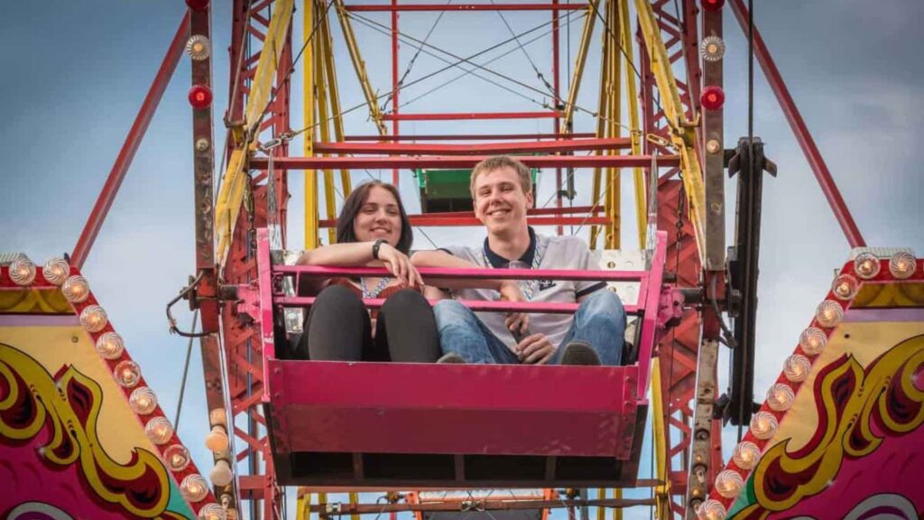 Two people sitting inside ferris wheel as it goes round