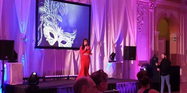 Speaker on stage giving out awards at Venice corporate gala dinner event.