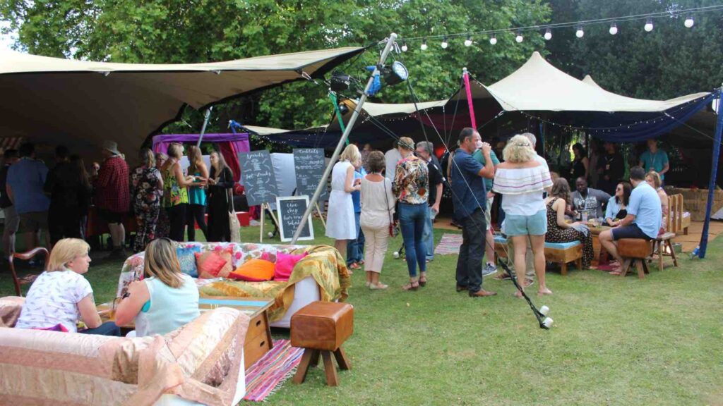 Vibrant mini-festival hire themed corporate fun day event with guests.