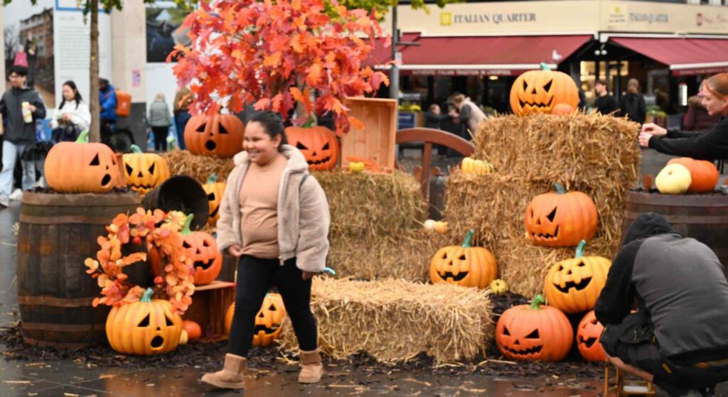 Bespoke Halloween community set design featuring halloween pumpkins, haystacks and child posing with it.
