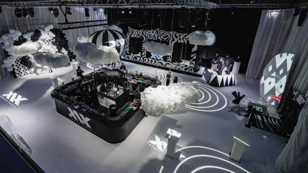 High-end event production with floating balloon bar in the clouds concept with projection lighting and stage.