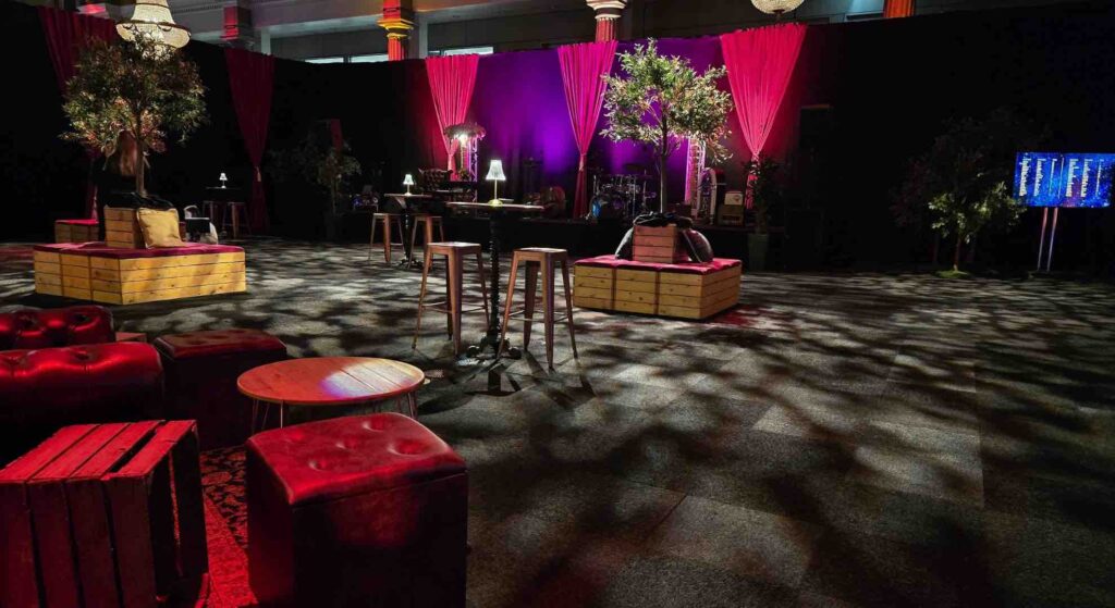 A jazz inspired set and stage design with opulent seating and red velvet curtains.