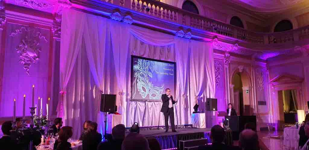 Host on stage presenting awards to select Signature Flights employees.