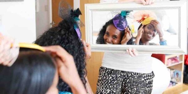 Guests-Looking-At-Fascinator-Creations-In-Mirror