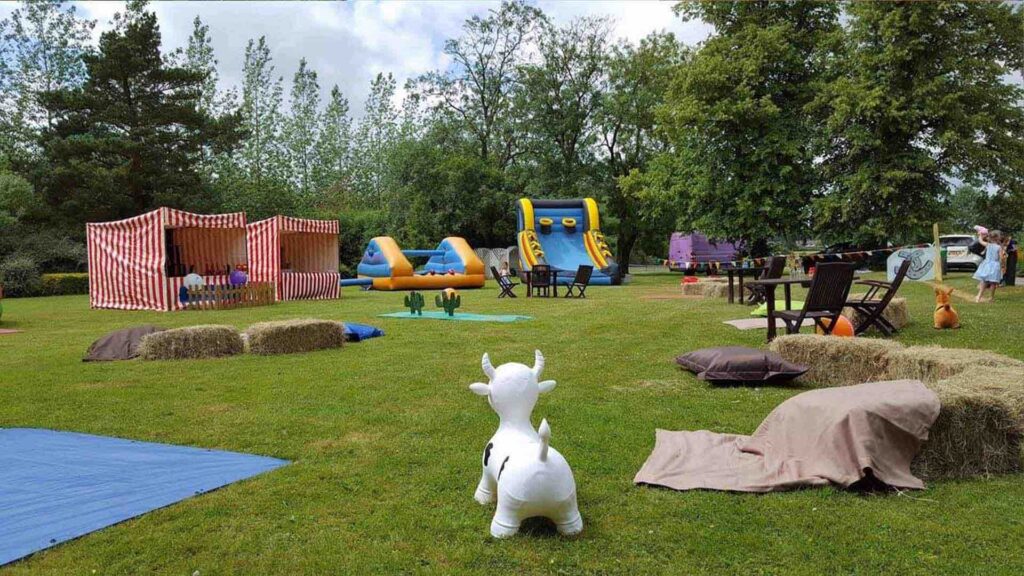 Inflatable slides, rodeo bull, toy cows and cactus toss as part of cowboy themed family fun day.