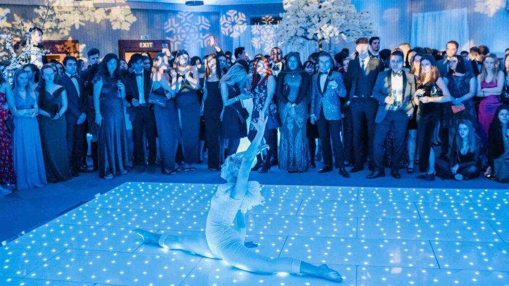 Christmas party entertainer performing on sparkling dance floor at Christmas party event.