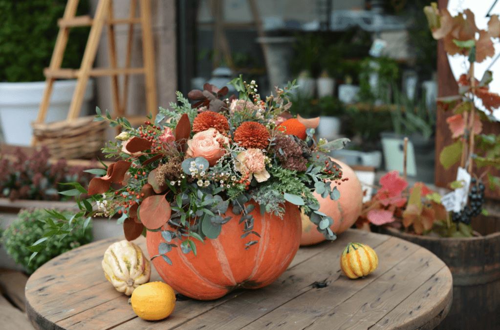 Pumpkin filled with seasonal flowers create at floral pumpkin making Halloween craft workshop.