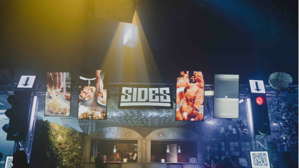 Sides food sign with TV screens showing food either side of the signs.