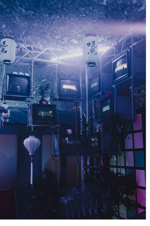 Old fashioned TV screens installed in corner of the room with Sidemen turn 8 logos showing on the screens.