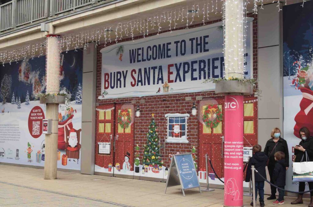 The outside of the Bury Santa Experience Christmas shopping centre activation, featuring branding and fairy lights.