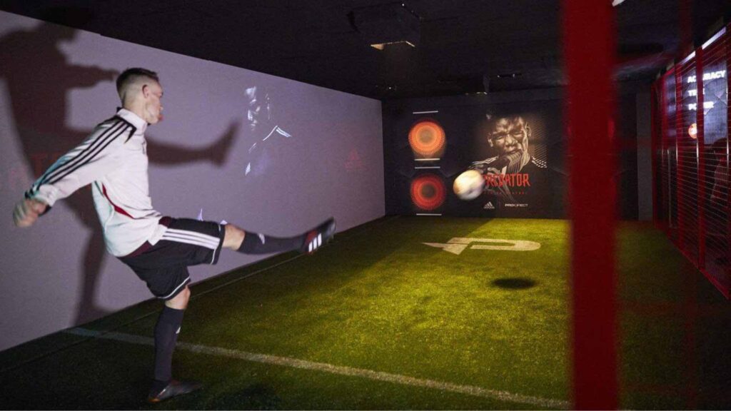 A male kicks a ball into the interactive football wall