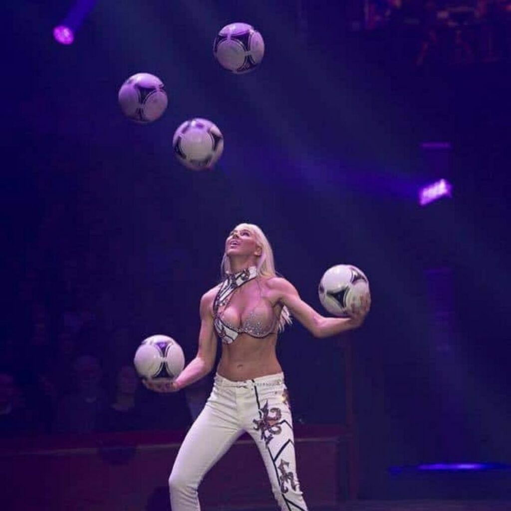 Juggler throwing footballs into the air to juggle