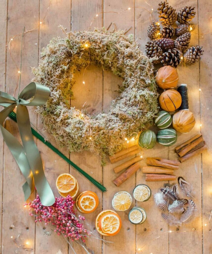 Moss covered wreath with decorative natural materials around it ready for virtual Christmas party wreath making.