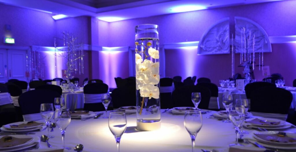 Clear cylinder glass table centrepiece with white Orchid inside to give the impression it is floating.