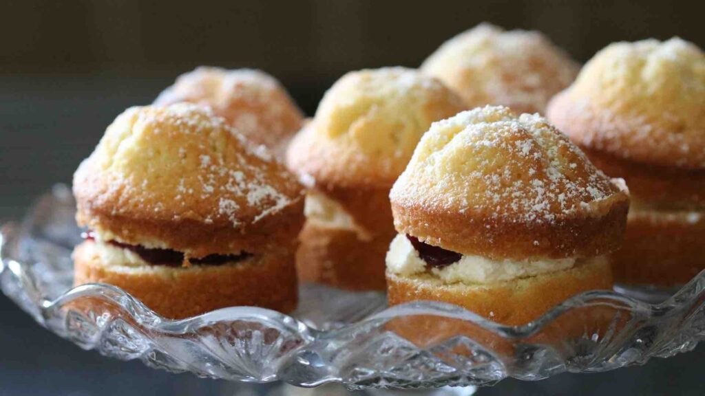 Mini victoria sponges displayed on glass cake display stand