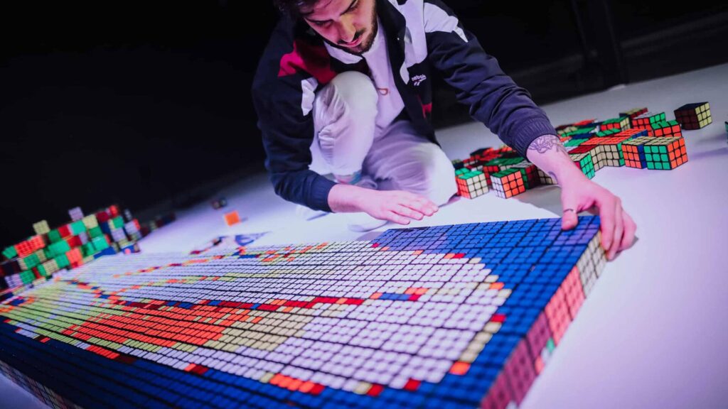 Artist creating a branded portrait out of Rubik's cubes for Reebok.