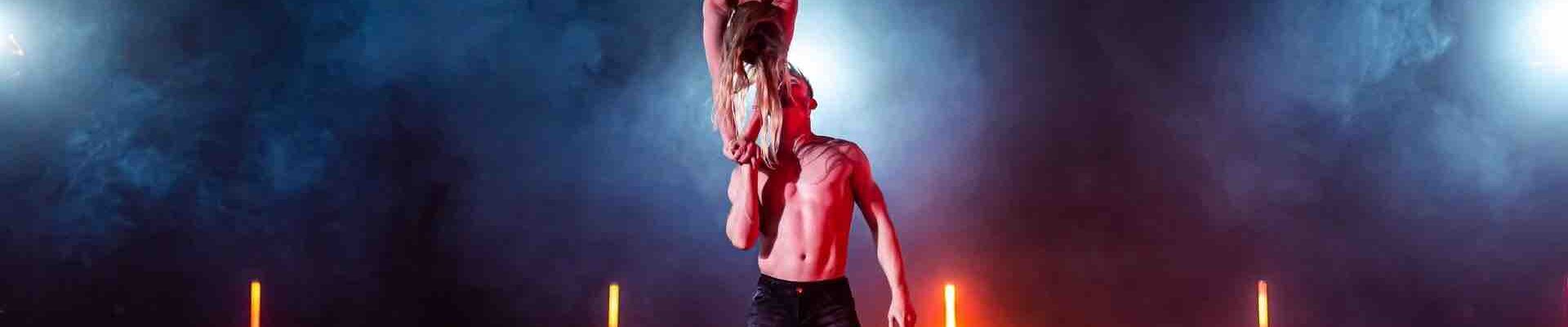 Female-Acrobat-Balancing-On-The-Hand-Of-Male-Acrobat Female-Acrobat-Balancing-On-The-Hand-Of-Male-Acrobat