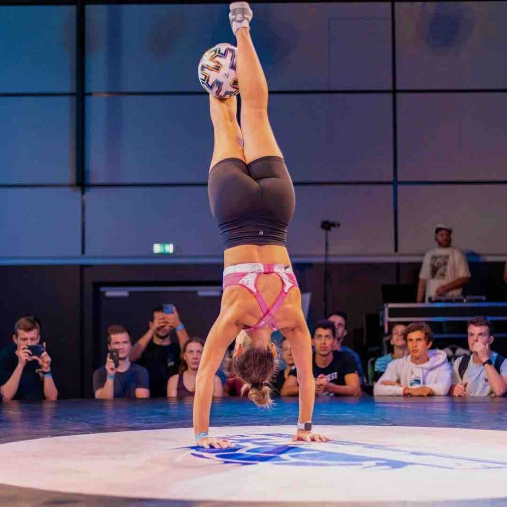 Football freestyler balances on two hands