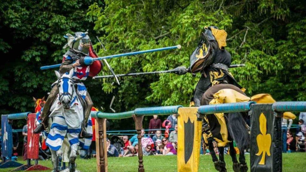 Two knights jousting in front of crowd