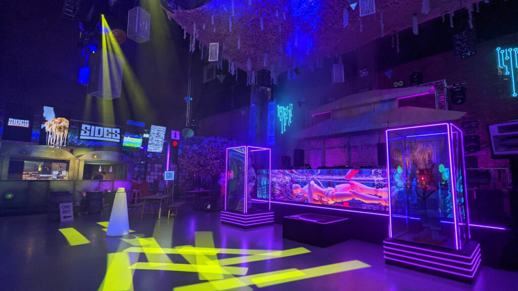 Neon themed event space with yellow and purple light projections.