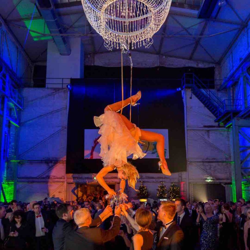 Champagne bartender hanging from chandelier rig