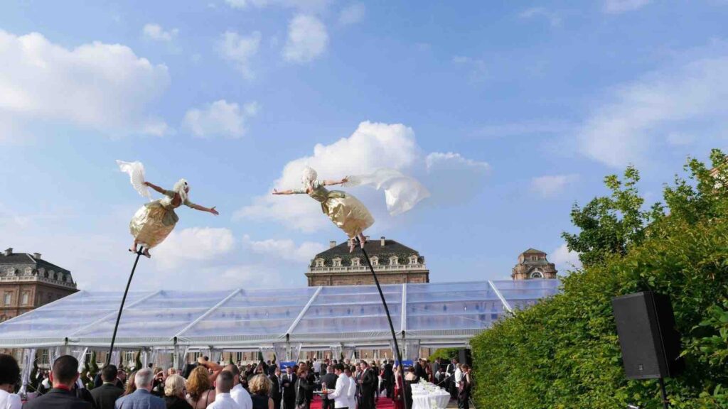 Two aerial dancers perform at outdoor event on sway poles