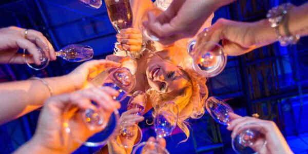 Guests-Hold-Glasses-Up-To-Aerialist-Performer