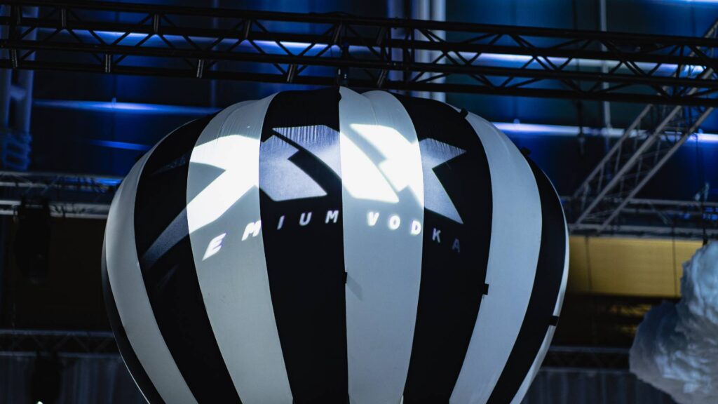 XIX brand lighting projected over black and white hot air balloon prop at influencer event brand activation.