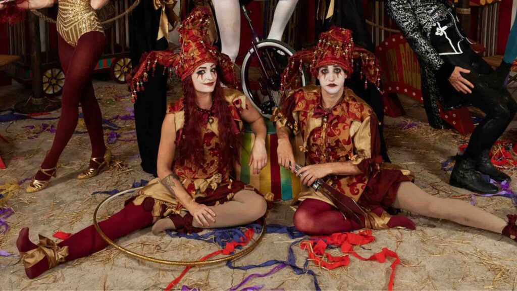 Clown entertainers sitting on the floor of big top tent