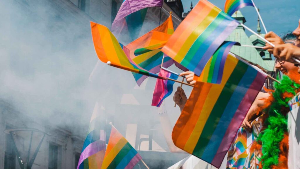 Pride celebration themed decorations of flags and banners at parade event.