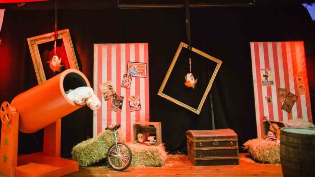 Twisted Circus Themed Event space with red and white striped backdrops and red cannon prop.