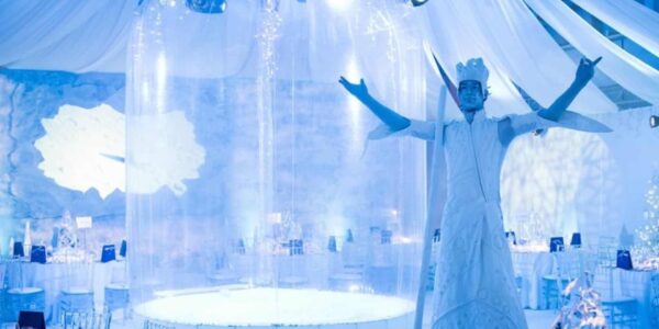 Ice-Themed-Stilt-Walker-Next-To-Snow-Globe