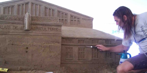 Artist-Creating-Building-From-Sand