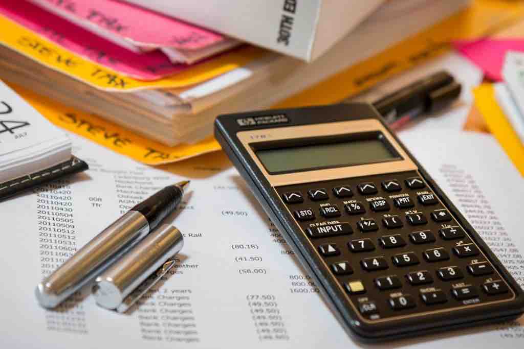 Pen, paper and calculator used to help event manager plan out budget.