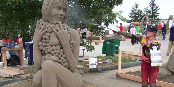 Sand-Artist-Spraying-Water-On-Sculpture