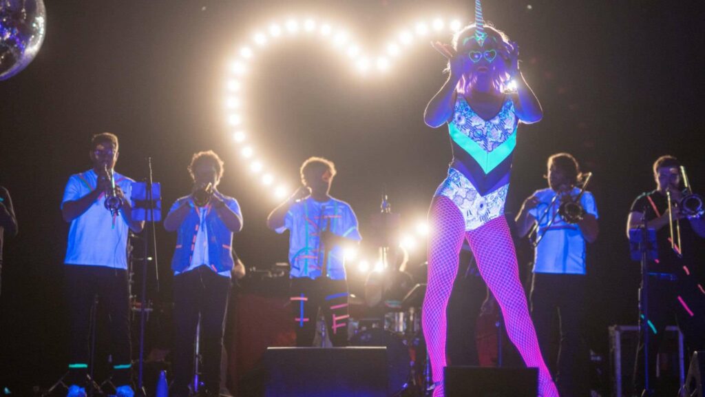Brass band performs with UV style drag entertainer