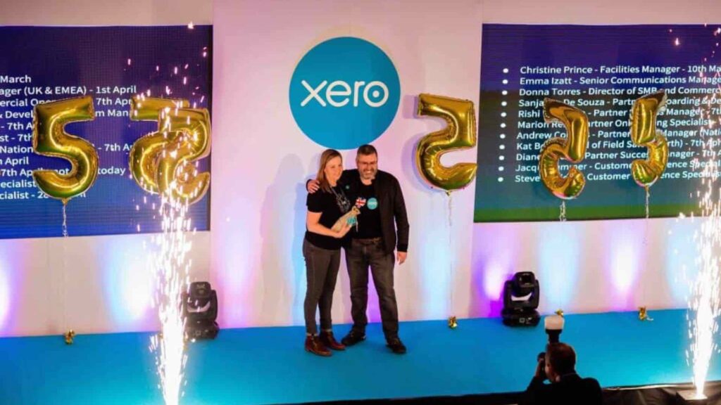 Award being presented to member of staff on stage at conference.
