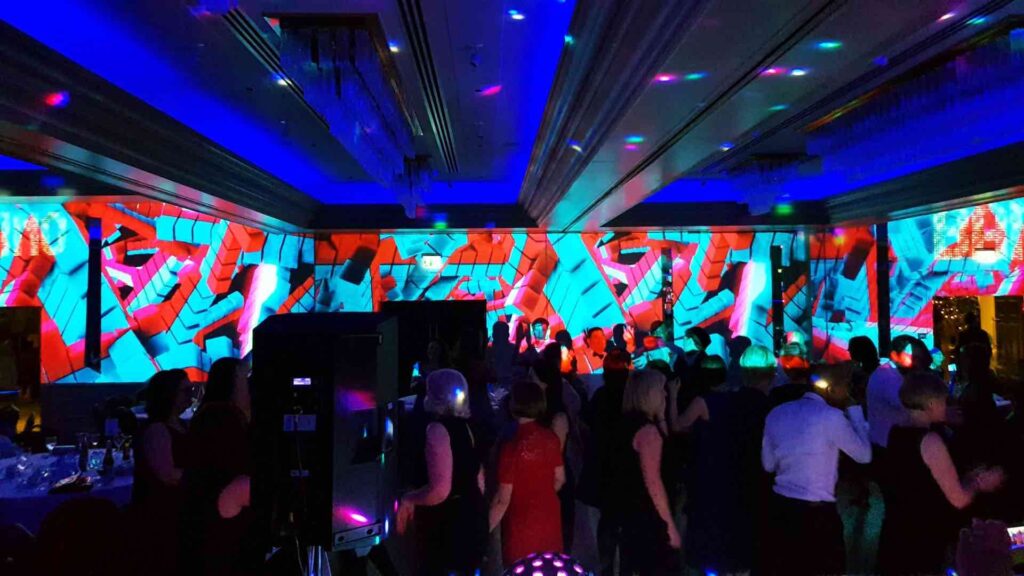 People at break out room in conference with projection mapping visuals on the walls.