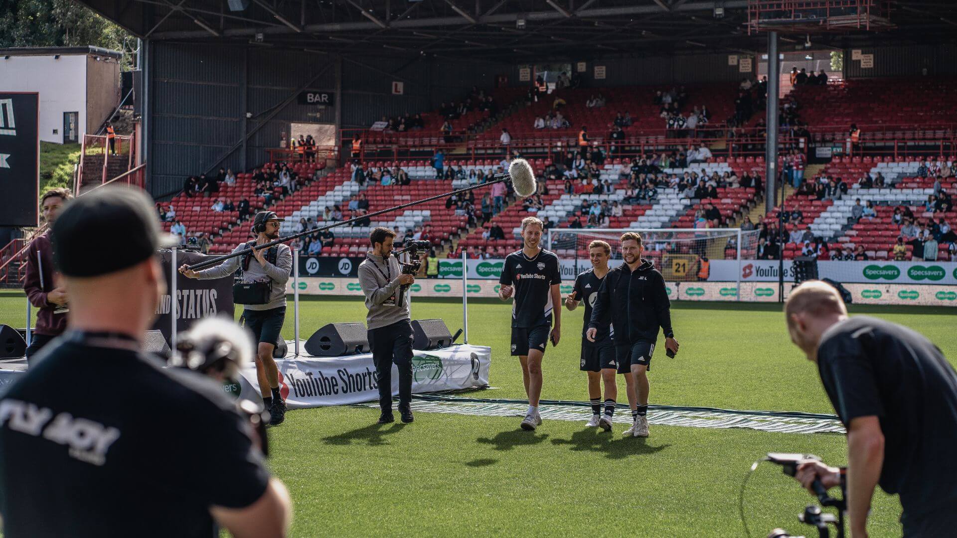 YouTubers Calfreezy, ChrisMD and Behzinga walking on the pitch at the Sidemen Charity Match 2022.