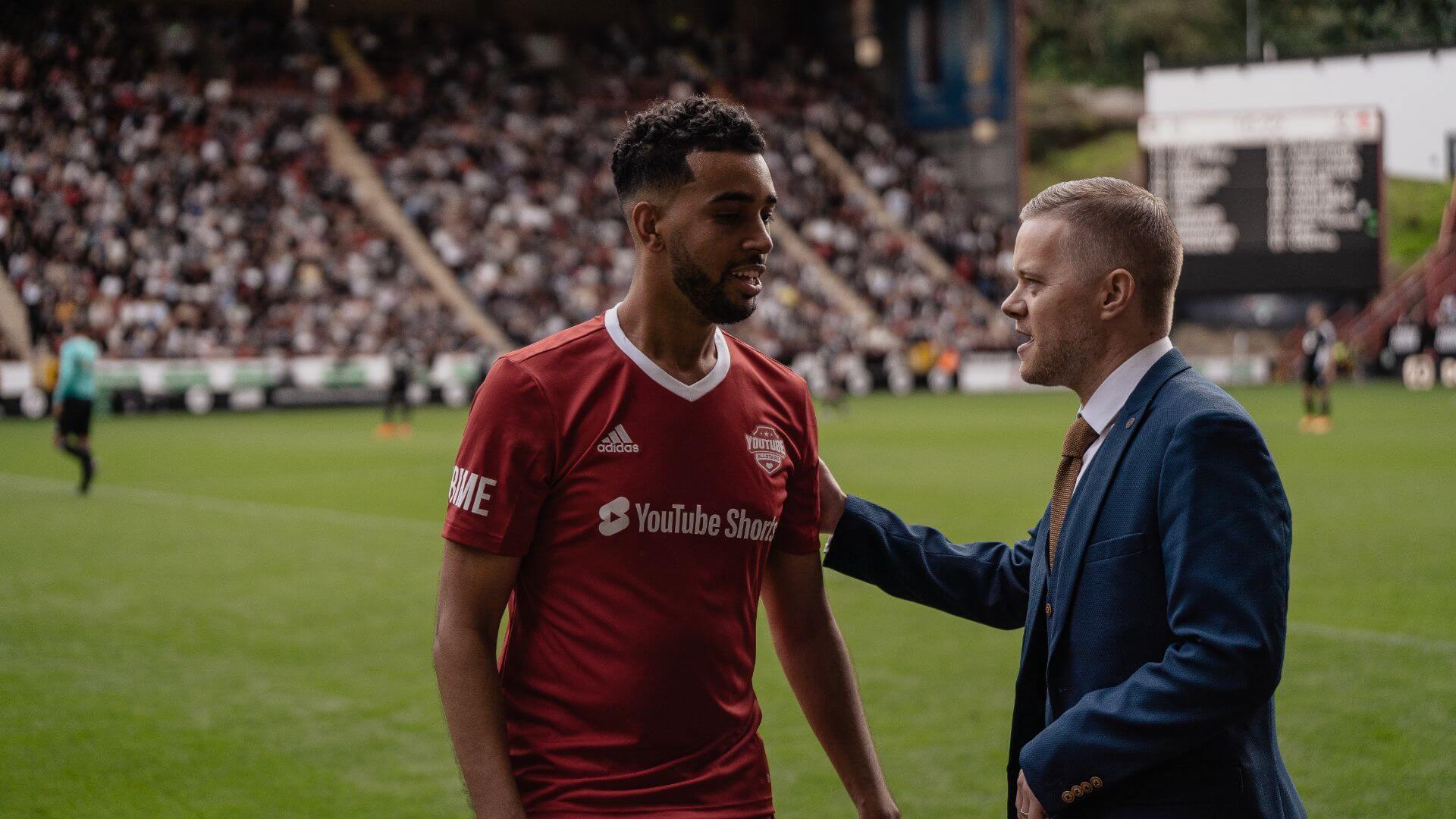Niko Omilana and Mark Goldbridge pitch side at the 2022 Sidemen Charity Match.