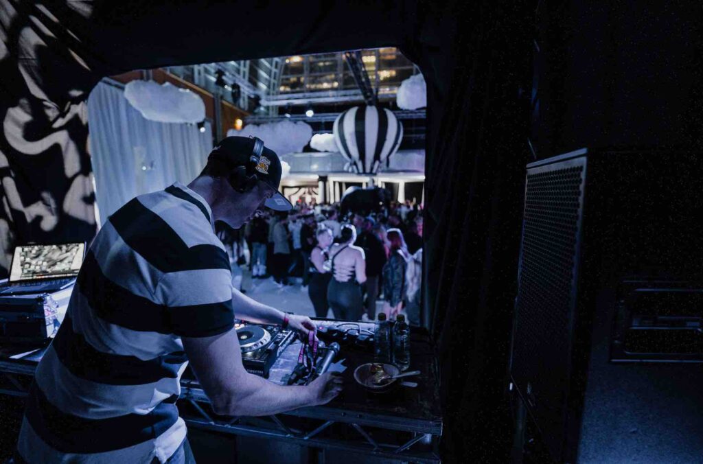 DJ performing in DJ booth at influencer party we created.
