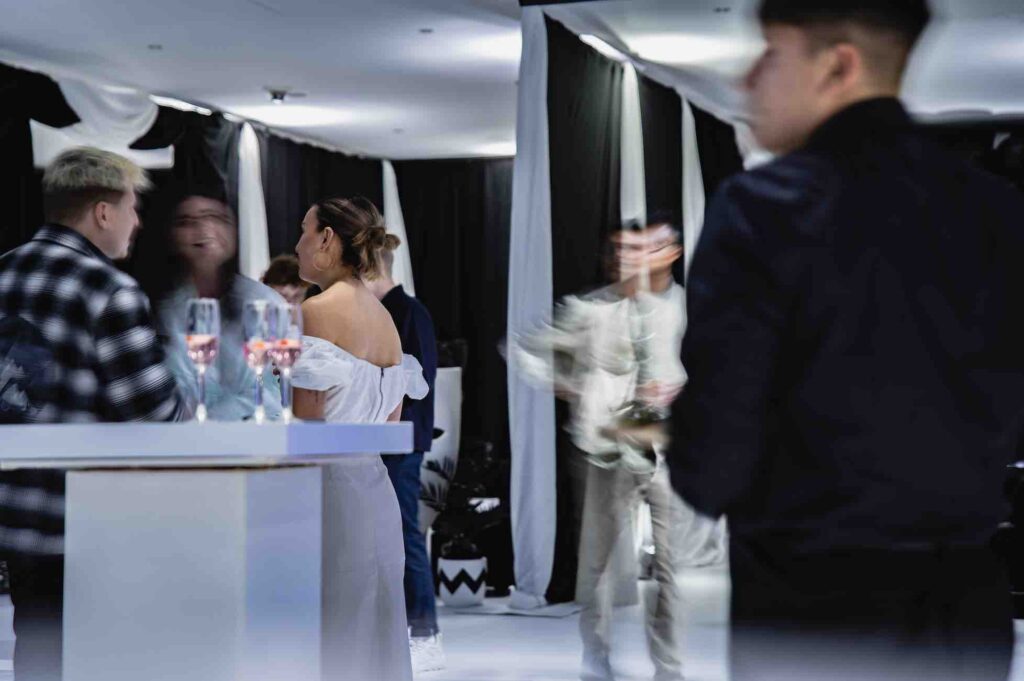 Guests networking in black and white event space at influencer party.