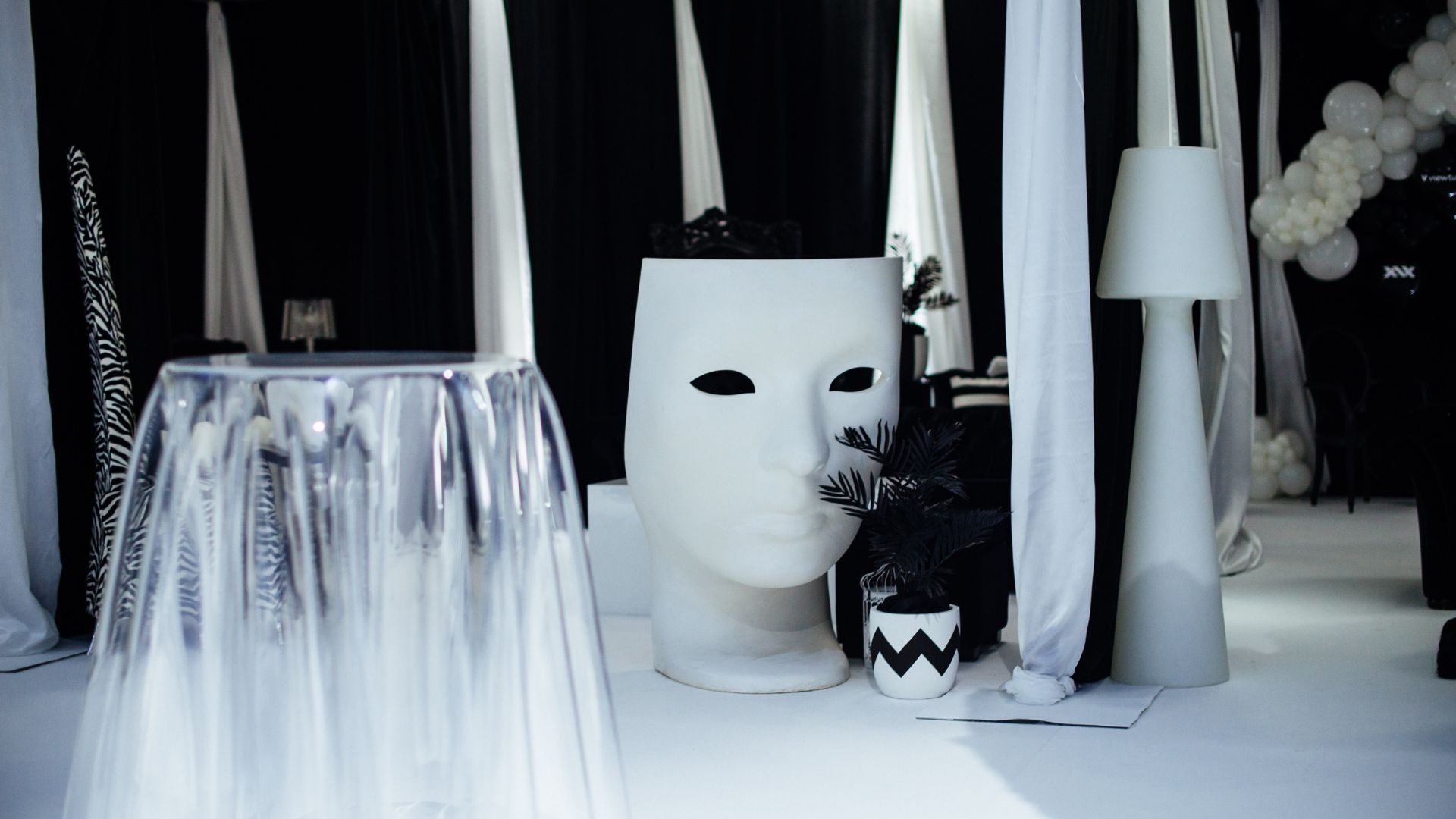 Standing tables and white mask prop used to decorate the event space.