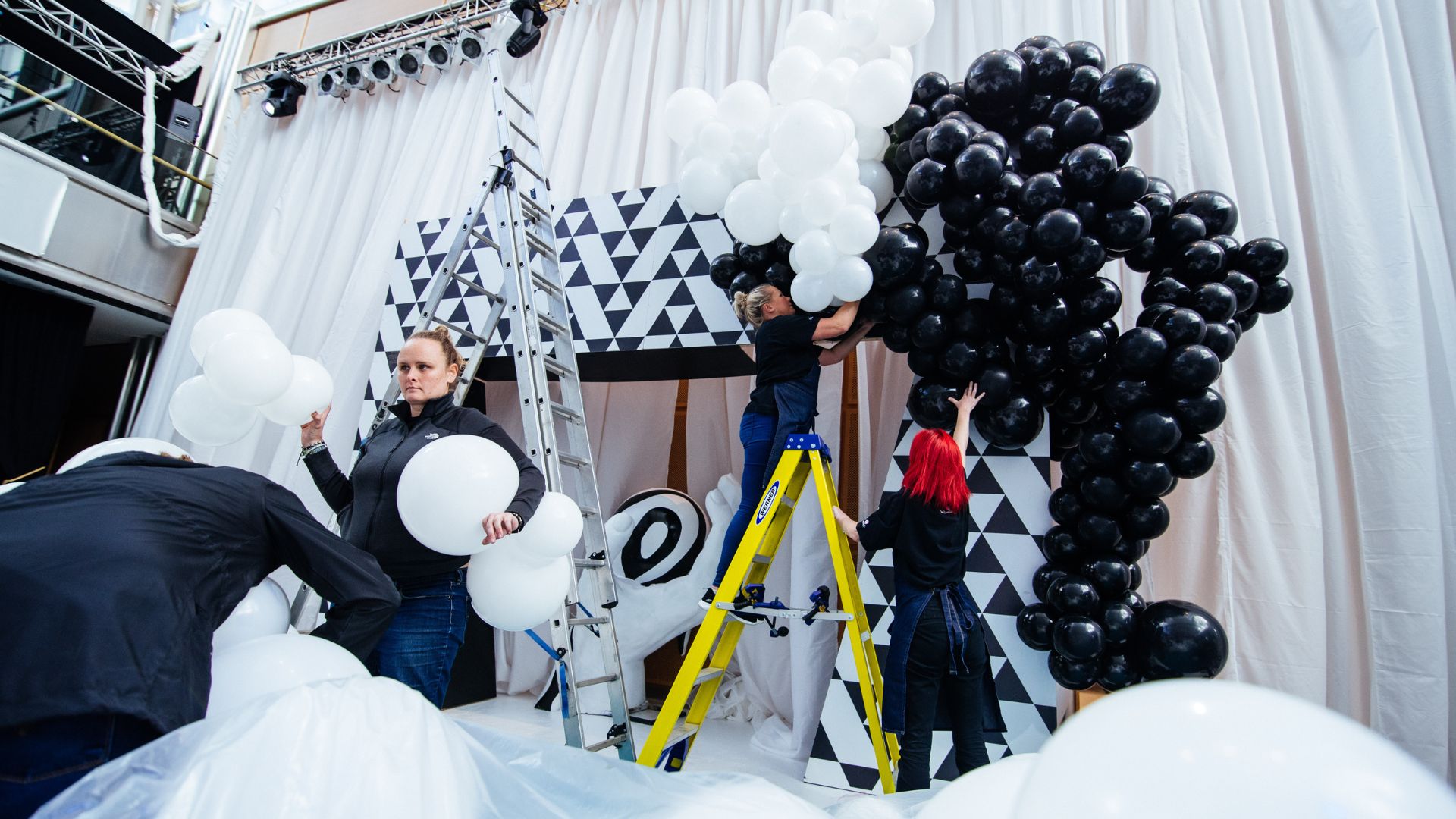 Setting up balloon backdrop in the entrance area of the Sidemen Charity Match after party.