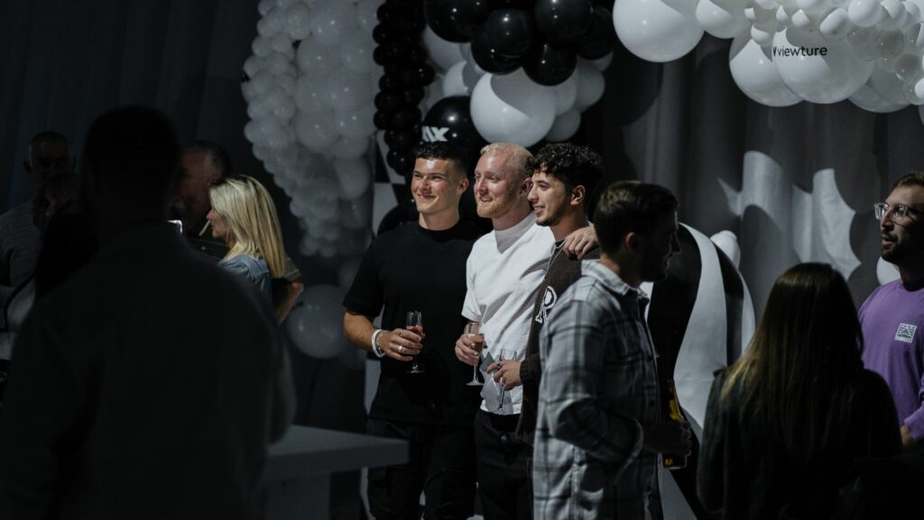 Theo Baker, TheBurntChip and guests taking photo by the branded balloon wall at the Sidemen charity match 2022 after party.