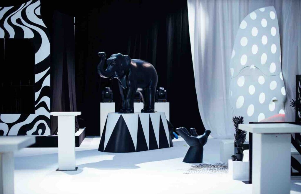 Elephant prop, spray painted black stood on top on black and white platform as part of props hired for dream circus party.