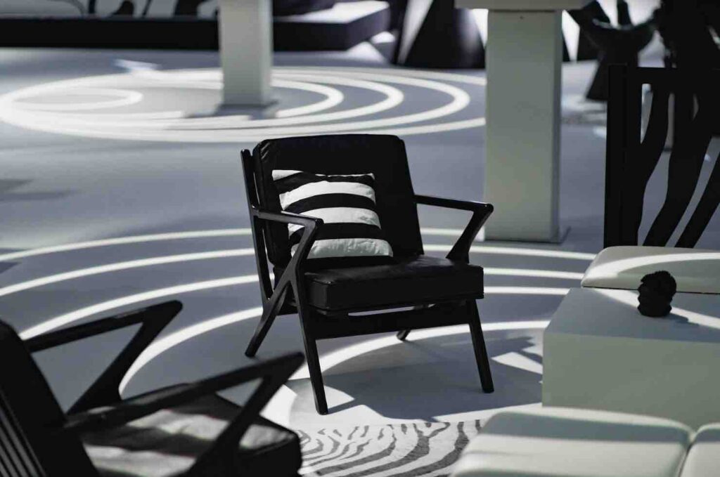 Black armchair with black and white striped cushion used as seating at black magic circus event.